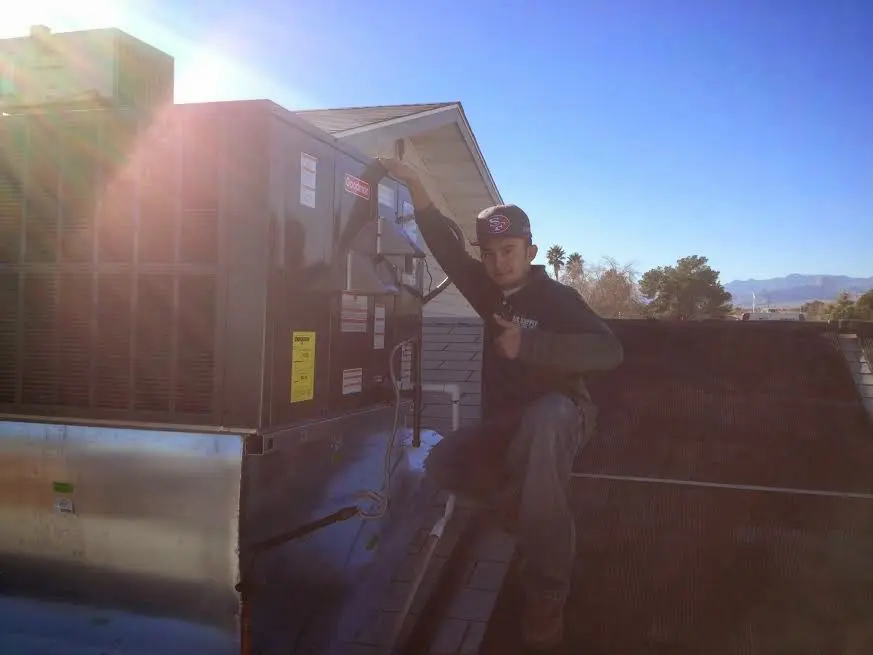 HVAC technician performing AC Tune-Up on a rooftop unit in Pennsauken